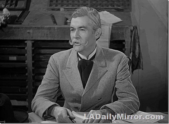 man with goatee sitting at desk. 