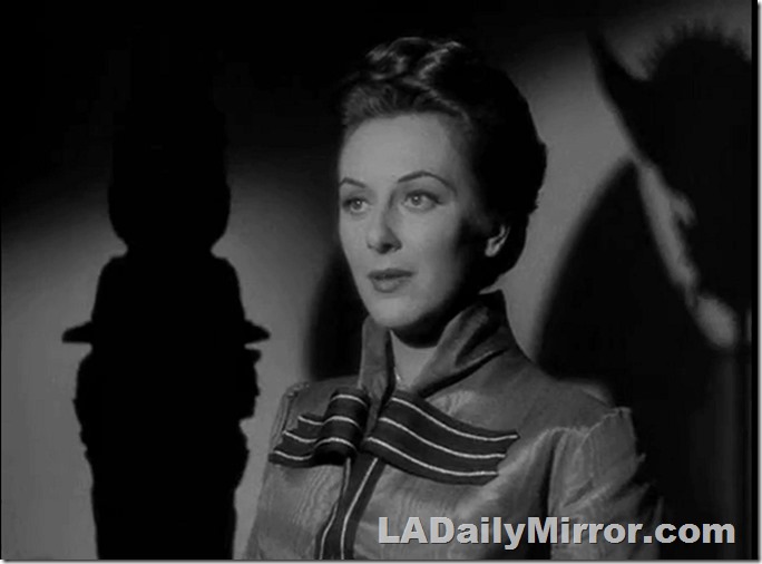 Woman in shadowy lighting that accents her jawline and cheekbones. 