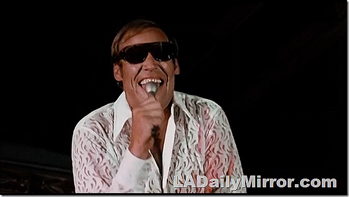 Man in sunglasses singing. 