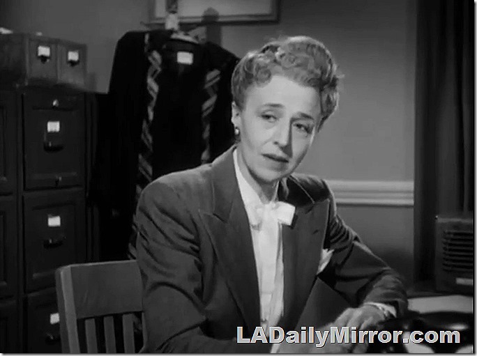 Woman sitting at desk in business attire. Woman sitting at desk in business attire.
