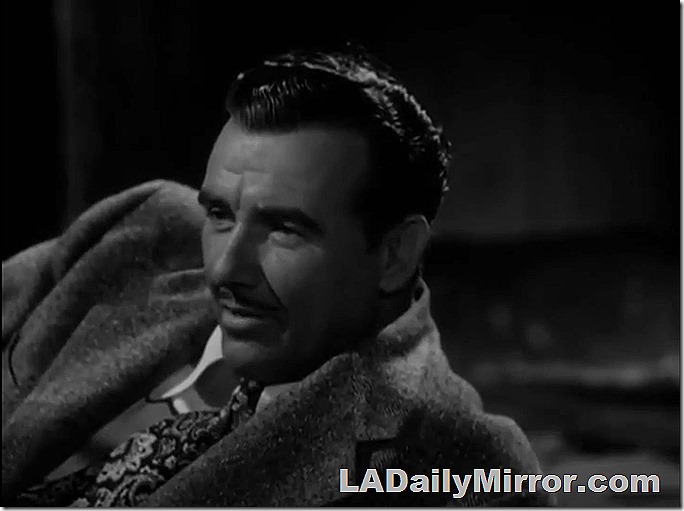 Man with mustache, wearing coat and tie, leaning on an elbow. Man with mustache, wearing coat and tie, leaning on an elbow.