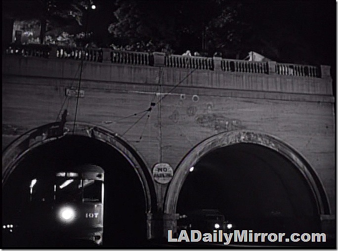 Two tunnels. A streetcar emerges from one of them. 