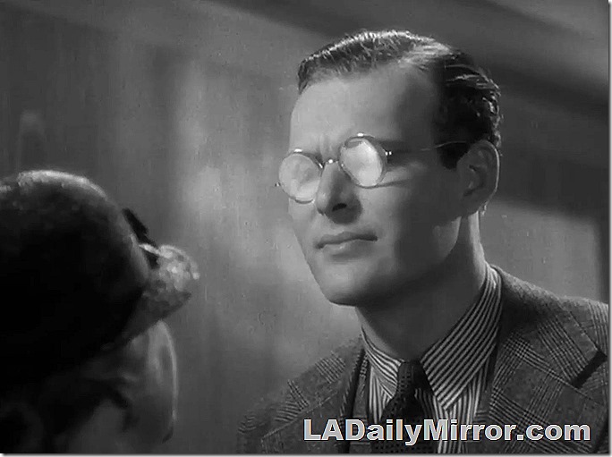 Man in three-piece suit, wearing glasses. 