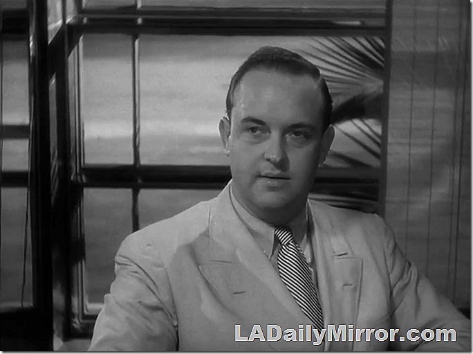 Dapper gent with palm fronds and ocean. 