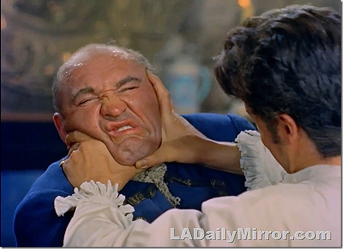 Man grimacing in a fight as his opponent scrunches his face. 