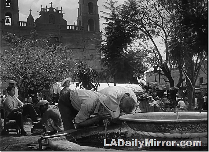 Two men wash their faces in a fountain on the plaza. Two men wash their faces in a fountain on the plaza.