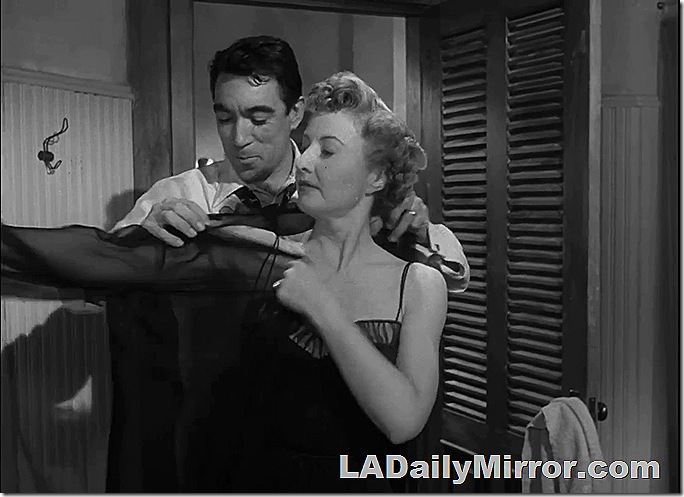 Man wearing tie with collar pulled open, woman putting on negligee. Man wearing tie with collar pulled open, woman putting on negligee.