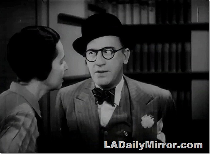 Man in a derby and funny glasses, a three-piece suit with a boutonniere. 