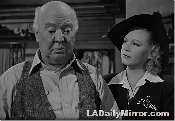 Guy Kibbee in vest and Gloria Dickson in hat and suit
