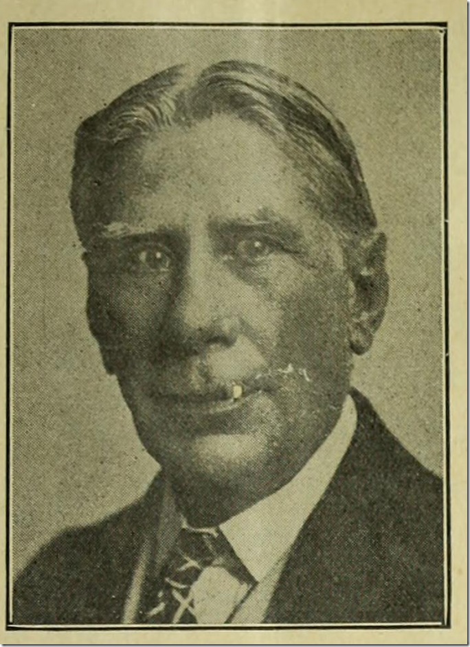 Portrait of Tote DuCrow in coat and tie.