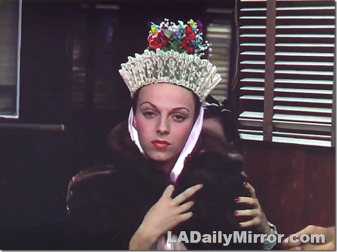 Woman in fur coat and ethnic headdress of lace and flowers. 