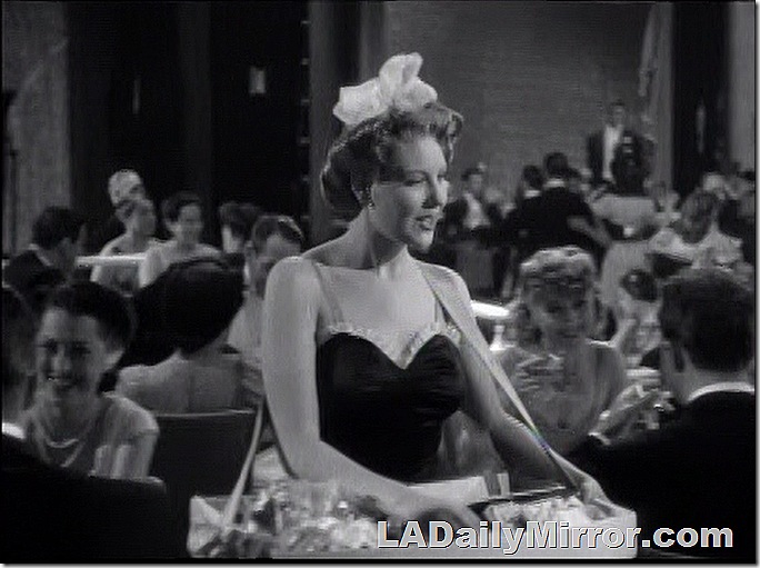 Woman in brief outfit selling cigarettes.