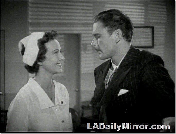 Nurse in white uniform. Man with mustache in pinstriped suit with wide lapels. 