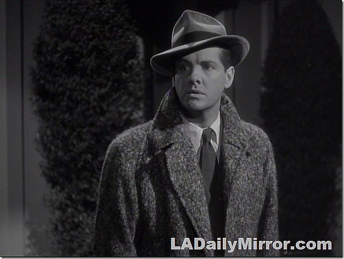 Man in overcoat and hat with a puzzled expression (the man, not the hat). 