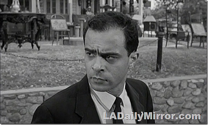 Man in suitcoat and tie, a serious look on his face. 