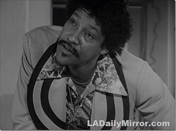 Man with mustache in 1970s fashions. 