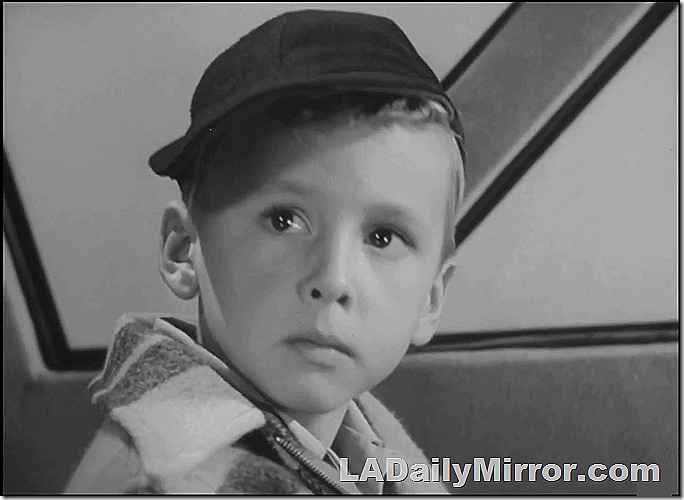 Boy in baseball cap and coat. 