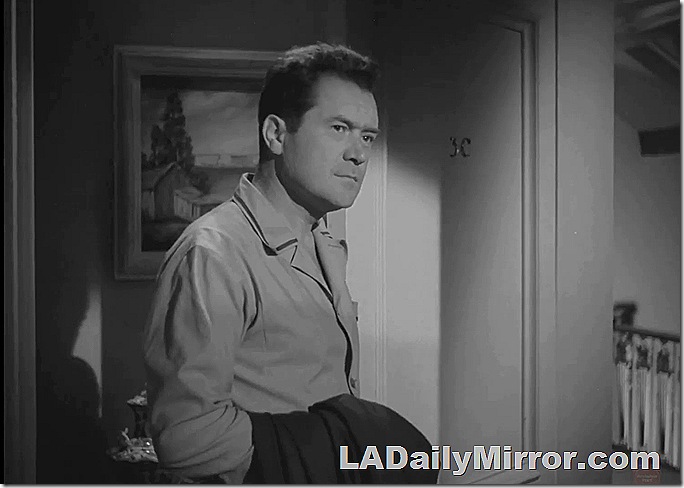 Man in shirt with coat slung over his arm. 