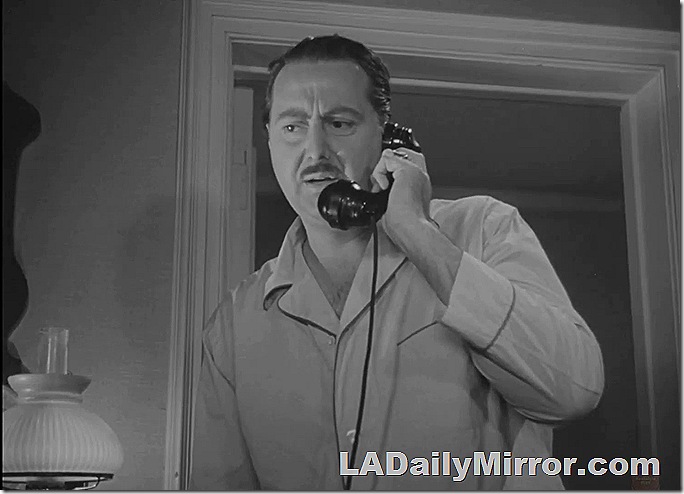 Man in pajamas talking on the telephone. 