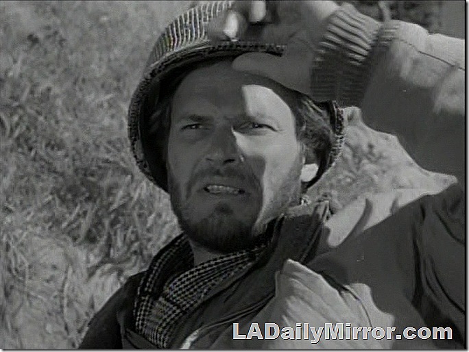 Man with beard, wearing Army helmet. 