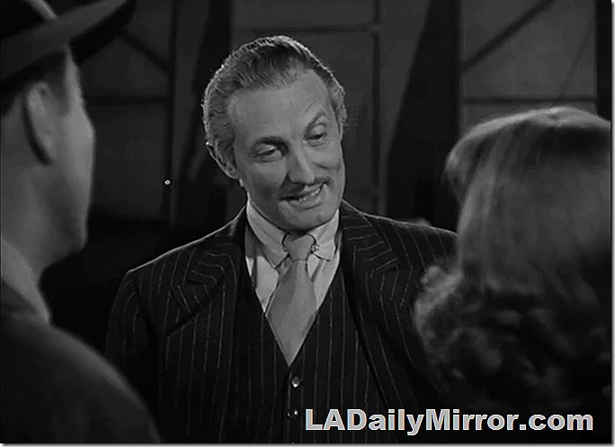 Man with a slight mustache, wearing a three-piece pinstripe suit. 