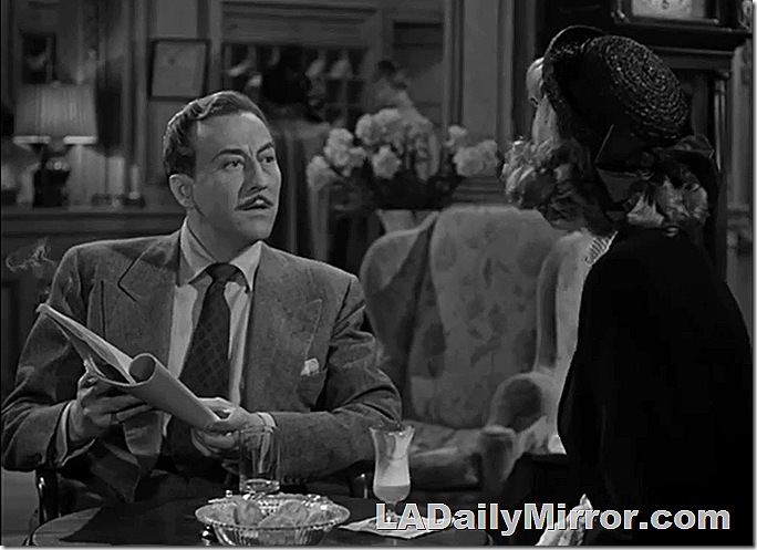 Man with mustache, wearing coat and tie, looking at Back of the Head Woman. 