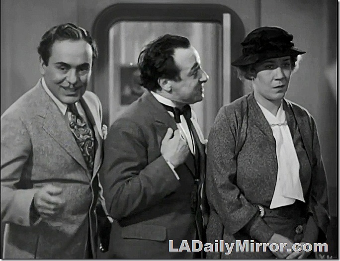 Two men and a woman. The first man is elegantly dressed. the second is a bit flustered and the woman is pensive. 