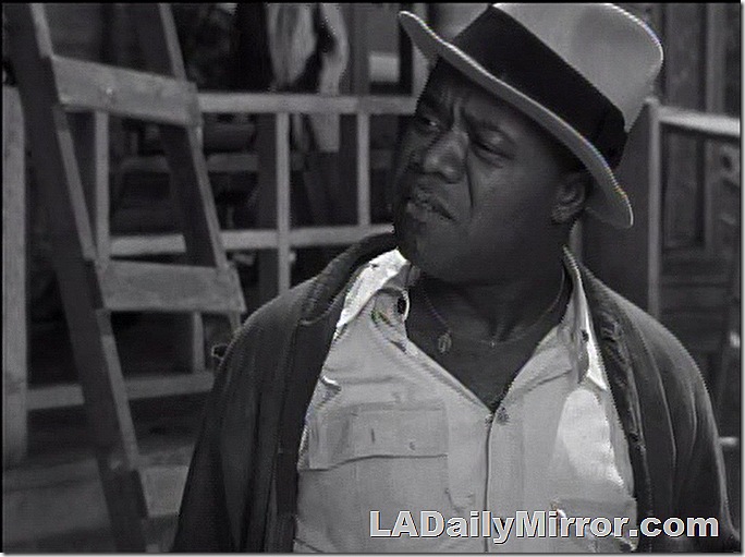 Man in hat, T-shirt, shirt and sweater. 