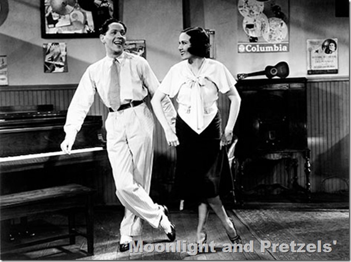 Man and woman strike a dance pose next to a piano. 