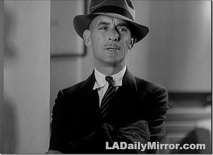 Man in hat, coat and tie with a small mustache. 