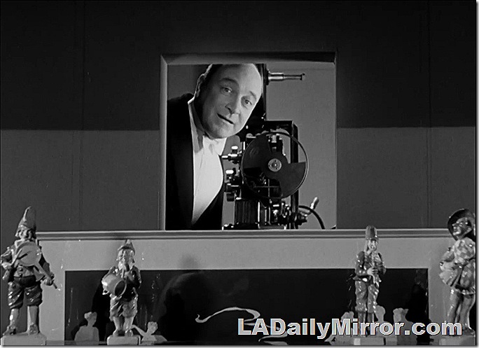 Man in tuxedo with movie projector. 