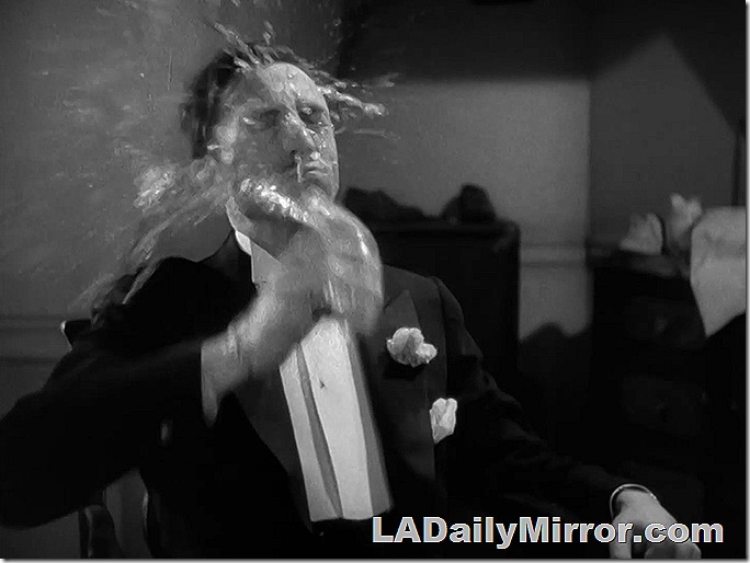 Man dousing his face with a glass of water. 