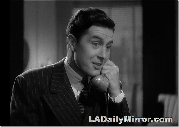 Man in pinstripe double breasted suit on the phone. 