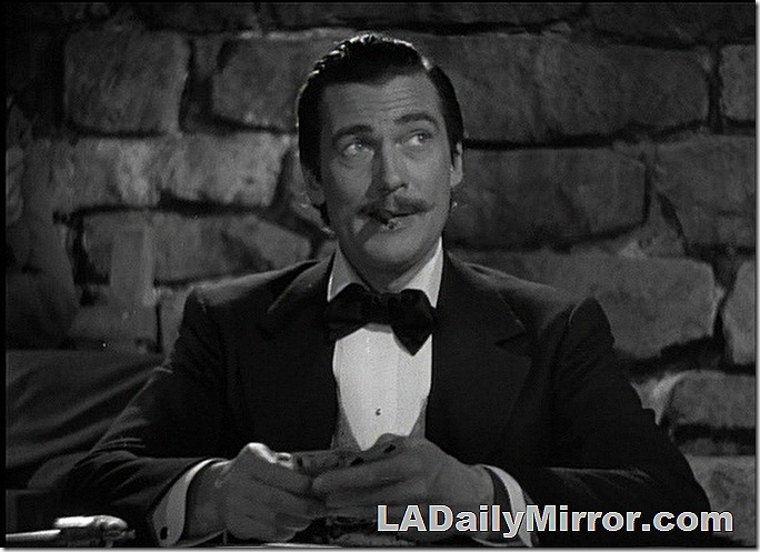 Man with mustache, smoking a cigar and playing cards. 