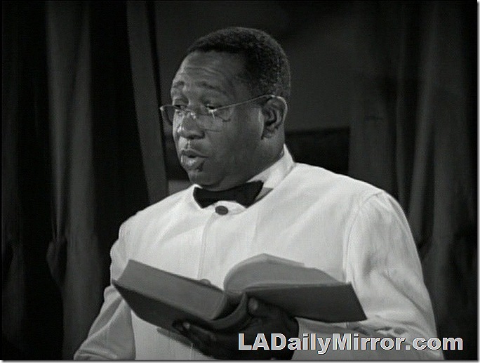 Man in white coat, bow tie, wearing glasses and holding a book. Man in white coat, bow tie, wearing glasses and holding a book.