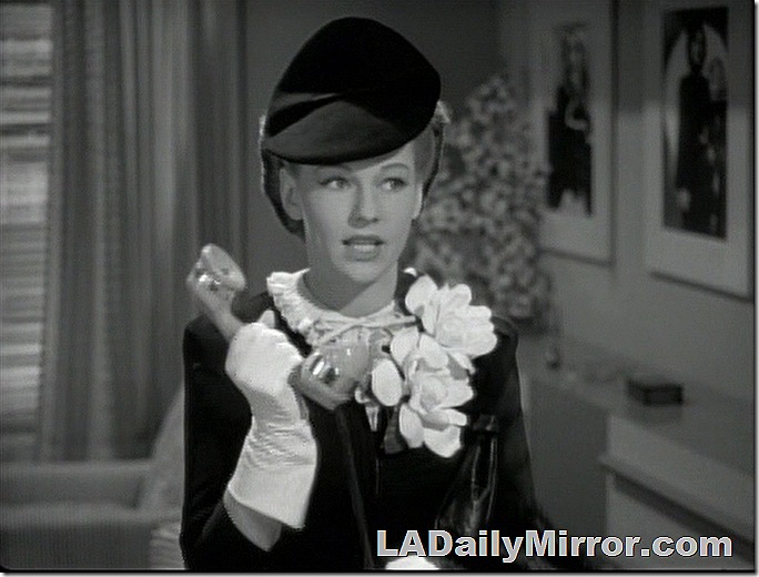 Woman in hat wearing large corsage, holding telephone. Woman in hat wearing large corsage, holding telephone.