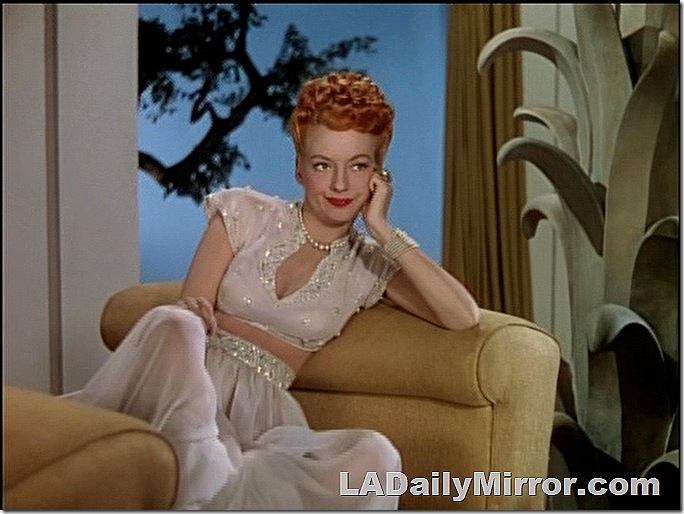 Woman in exotic, filmy costume on couch looking bored. Woman in exotic, filmy costume on couch looking bored.