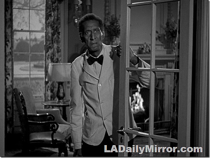 Man in white coat and bow tie looking out French doors. Man in white coat and bow tie looking out French doors.
