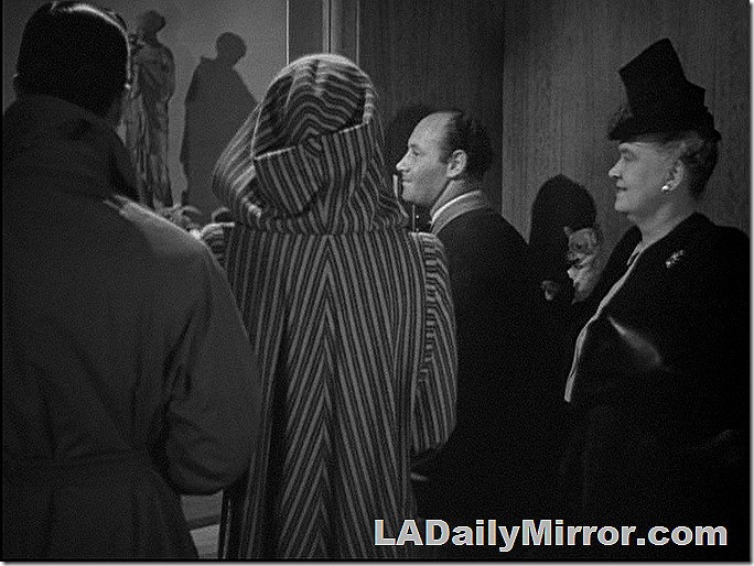 People in an elevator: The elevator operator, a well-dressed older woman and our leading man and lady with their backs to the camera. People in an elevator: The elevator operator, a well-dressed older woman and our leading man and lady with their backs to the camera.