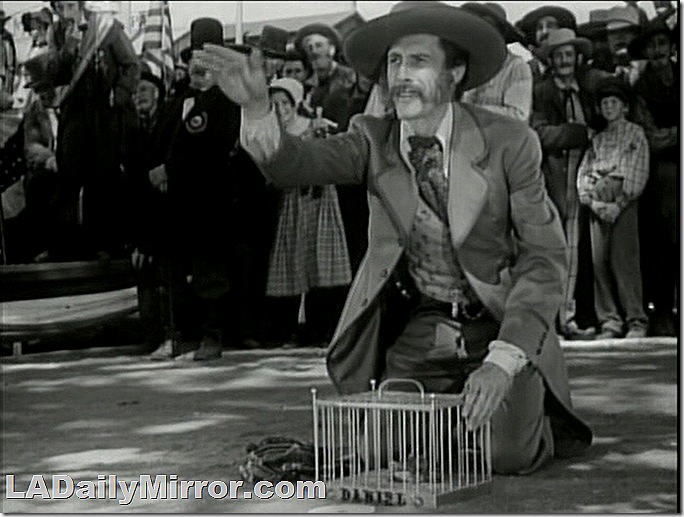 Man with sideburns and a mustache, kneeling next to a cage. Man with sideburns and a mustache, kneeling next to a cage.