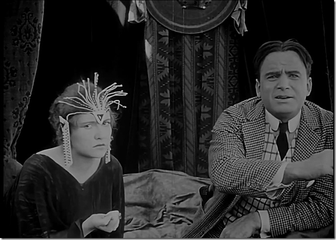 Woman in robe with bizarre jewelry on her forehead. 