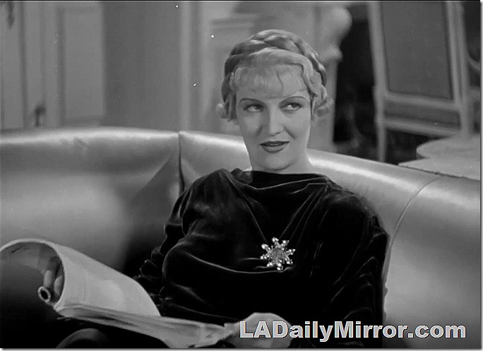 Woman sitting on a couch. She's in elegrant dress with fancy brooch. Her hair is up in a braid. Woman sitting on a couch. She's in elegrant dress with fancy brooch. Her hair is up in a braid.