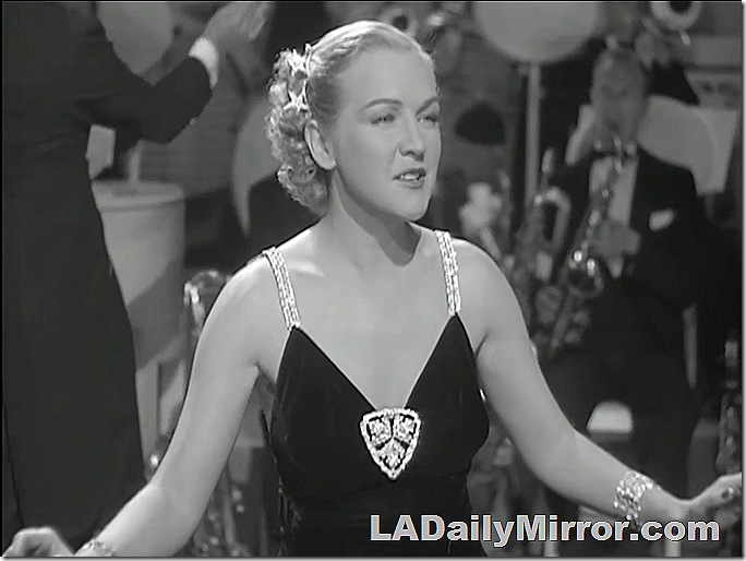 Mysterious blonde woman in revealing dress with lots of sparkles. 