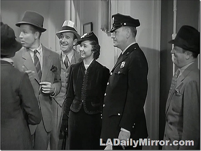 Mysterious woman standing between a police officer and a man in a three-piece suit. 
