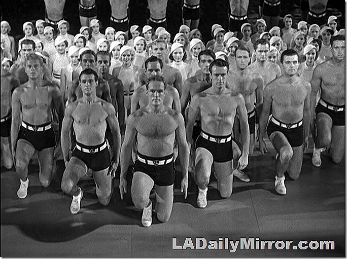 Dance number with men in swim trunks, shoes and socks, women in athletic outfits. 