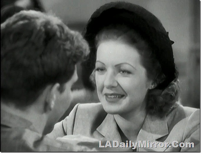 Woman with hat and coat talking to Back of the Head Guy. 