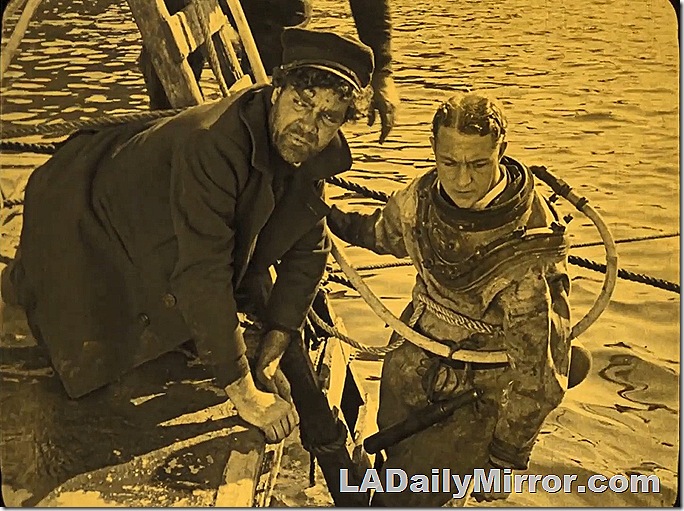Man putting on diving suit as another man watches. Man putting on diving suit as another man watches.