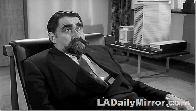 Man in suit with beard and mustache, sitting in chair. Man in suit with beard and mustache, sitting in chair.