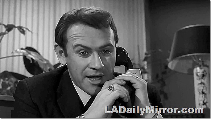 Man in suit, sitting at desk, talking on the phone. Man in suit, sitting at desk, talking on the phone.