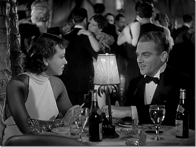 Man and woman at table in nightclub. 